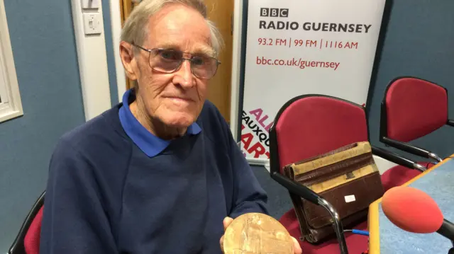 Alex Allan with a plaque remembering his uncle that was presented to his family