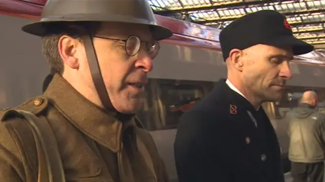 Man dressed as a WWII soldier at Stoke on Trent railway station reading the names of fallen soldiers