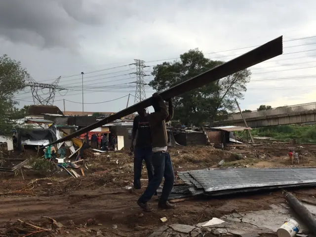People clearing up after floods in Johannesburg, South Africa