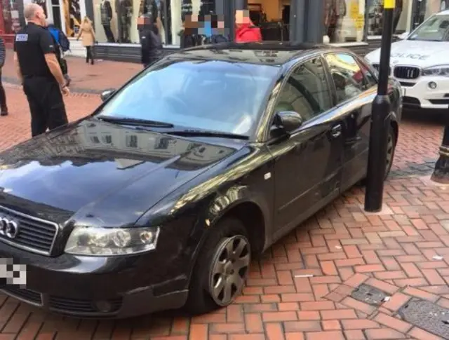 Car with burst tyre mounts pavement