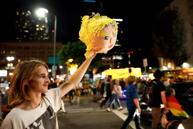 Protester holds a pinata head of Trump in LA
