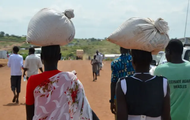 South Sudanese women carry food inside the Protection of Civilians (PoC) site located at the United Nations Missions in Sudan (UNMIS) on September 17, 2014 in Juba.