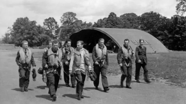 Airmen walking past a hangar