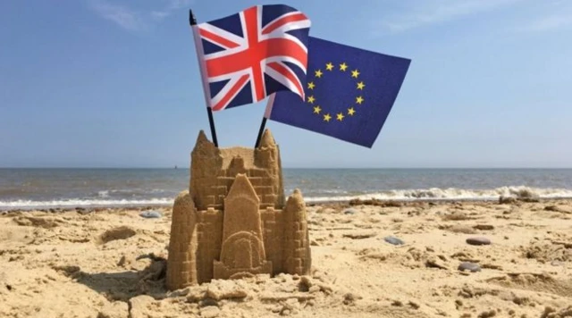 Sandcastle with EU and UK flags