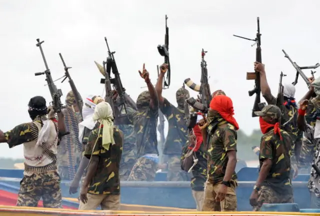 Fighters with the Movement for the Emancipation of the Niger Delta (MEND) raise their riffles to celebrate news of a successful operation by their colleagues against the Nigerian army in the Niger Delta on September 17, 2008.