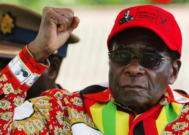 Zimbabwean President Robert Mugabe raises his fist on May 29, 2008 at a rally in Mvurwi some 100km from Harare.