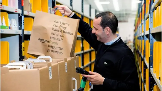 Amazon warehouse worker with bag of groceries