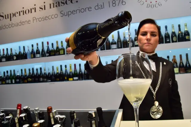 A waiter pours prosecco