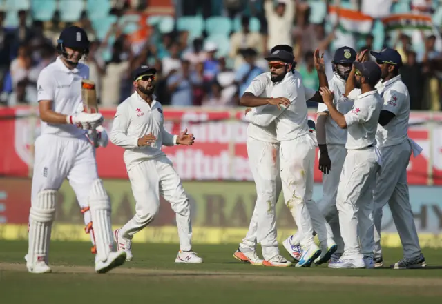 Members of the India team celebrate the dismissal of England's Joe Root