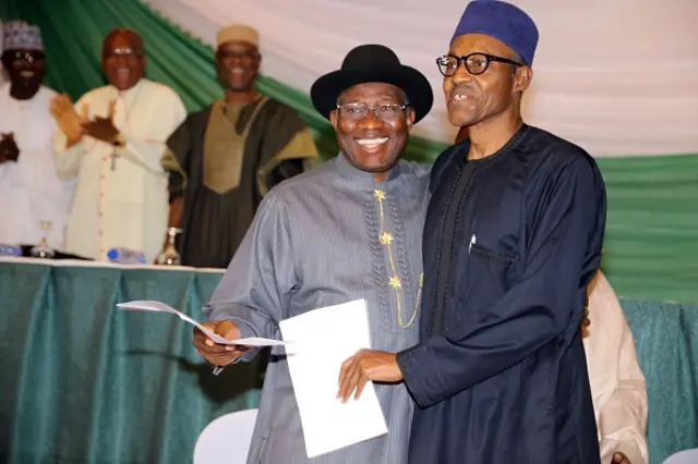 Nigerian President Goodluck Jonathan (C) and APC main opposition party's presidential candidate Mohammadu Buhari (R) smile after signing the renewal of the pledges for peaceful elections on March 26, 2015 in Abuja