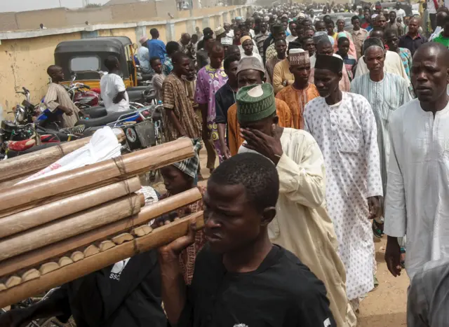 mourners carry bodies of those killed in clashes