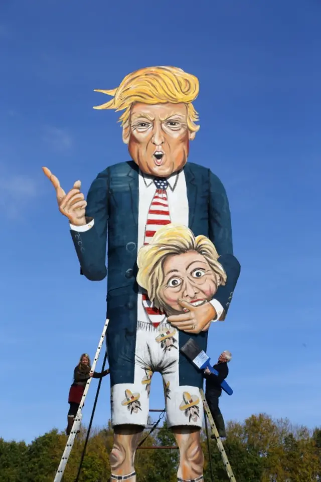 Artists Frank Shepherd and Andrea Deans put the finishing touches to the Edenbridge Bonfire Society celebrity effigy depicting US Presidential hopeful Donald Trump carrying the head of rival Hilary Clinton, after being unveiled in Edenbridge, England, Wednesday Nov. 2, 2016. The Edenbridge effigy always portrays a figure from the news, before being set afire on Britain's traditional bonfire night 5 November.