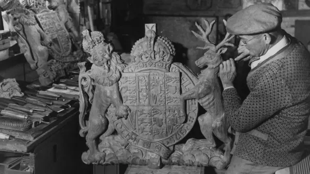 3 November 1936: A craftsman carves Queen Mary's coat of arms for the new St Catherines Church in Norwich.