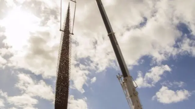 The sculpture being put in place