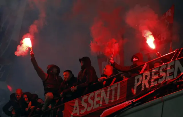 Fans light flares in the crowd