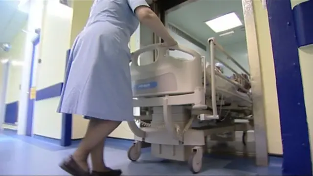 Hospital nurse pushing a bed