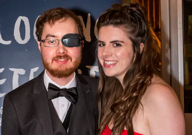 Dan, wearing glasses with an eye patch and his wife Kim