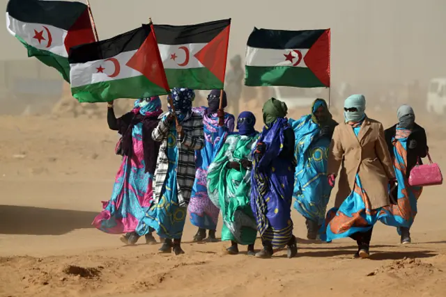 Sahrawi women hold Polisario Front's flags during a ceremony to mark 40 years after the Front proclaimed the Sahrawi Arab Democratic Republic (SADR) in the disputed territory of Western Sahara on February 27, 2016 at the Sahrawi refugee camp of Dakhla which lies 170 km to the southeast of the Algerian city of Tindouf.