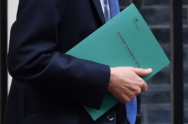 Chancellor Philip Hammond carries a copy of his