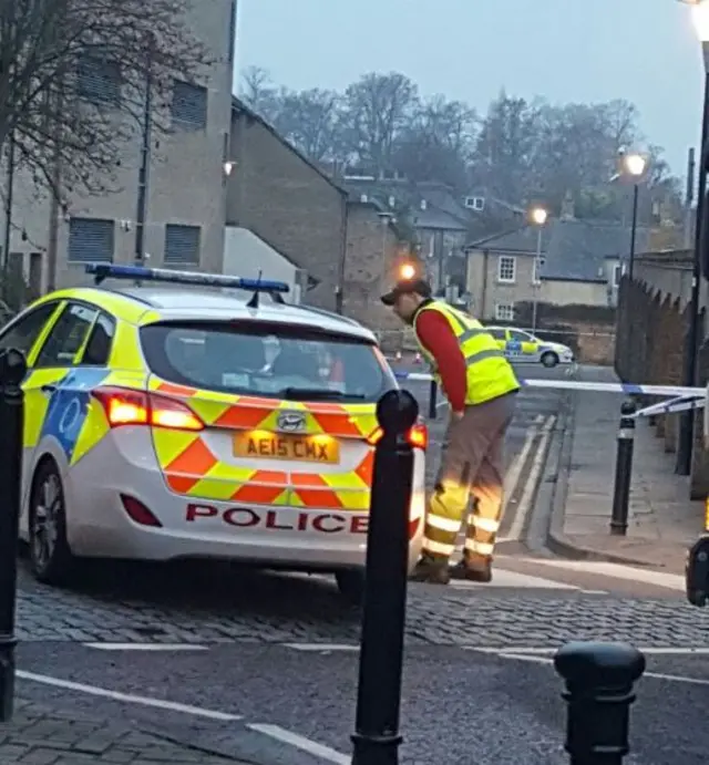 Fitzroy St, Cambridge with police car and man