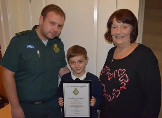 Paramedic Luke Jones, George Clarke with his certificate, and his great grandmother