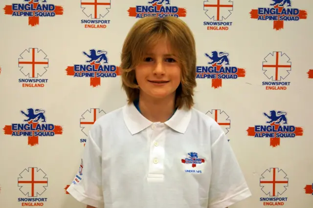 Joseph Thompson in white sport top with England Alpine Squad backdrop