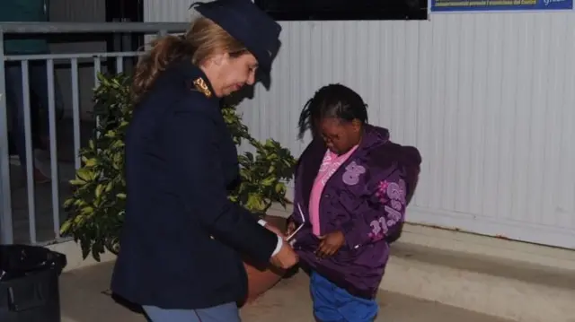 This handout picture released by the Italian police (Polizia di Stato) on November 23, 2016, shows police officer Maria Volpe taking care of Oumoh, 4,