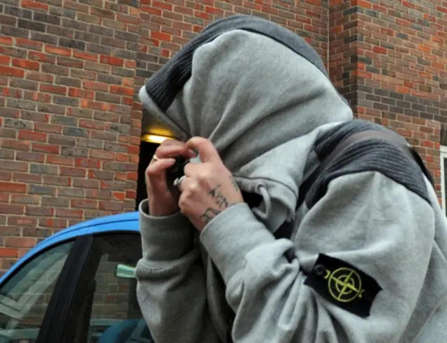 Sammi Horner, in grey sweat top and hoodie pulled over her head, leaving Norwich magistrates court