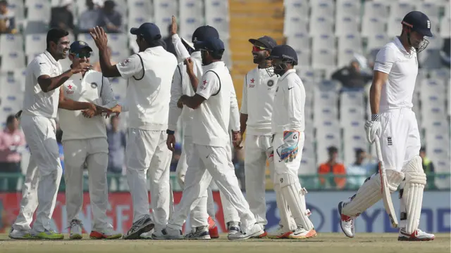 India's players celebrate the wicket of Alastair Cook