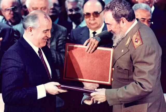 Soviet leader Mikhail Gorbachev (L) and Fidel Castro exchange documents