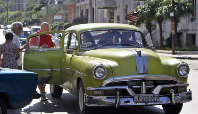 Tourists get into a car in Havana, November 2016