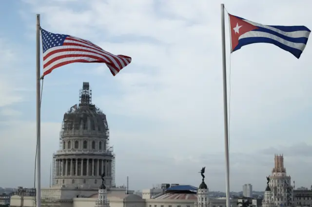 American flag flies next to a Cuban flag near El Capitolio in Old Havana on 20 March 2016