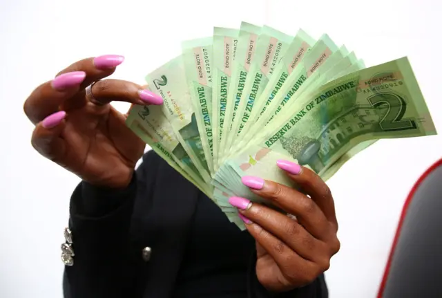 A woman holding bond notes