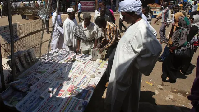 People gather around a newspaper stand