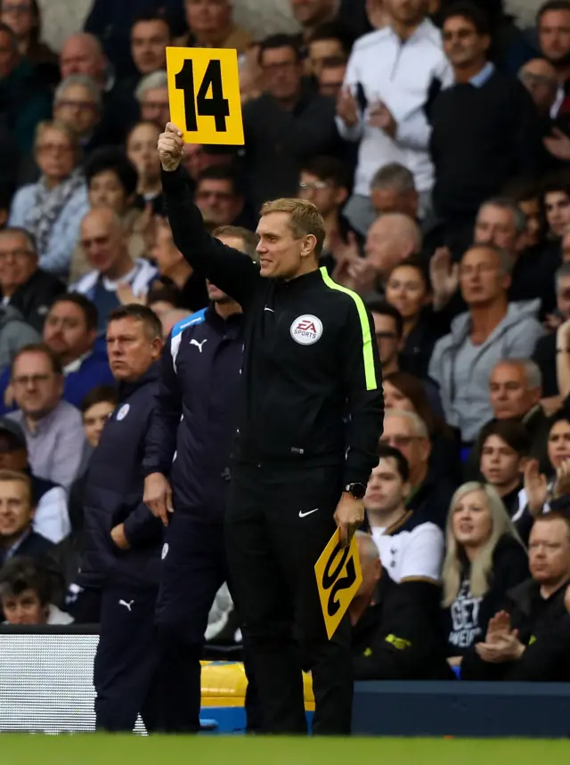 Fourth official holds up board