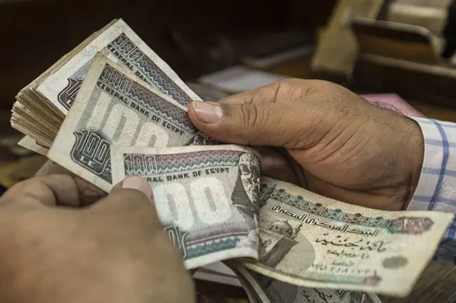 A man counts Egyptian pounds at currency exchange shop in downtown Cairo on November 3, 2016.