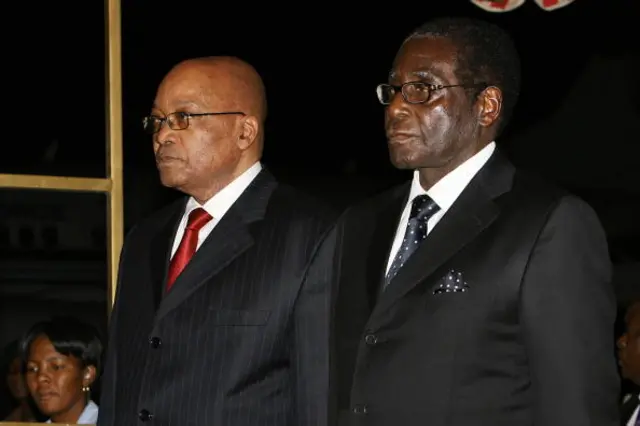 Zimbabwean President Robert Mugabe (R) welcomes South African President Jacob Zuma (L) upon his arrival at Harare international airport on August 27, 2009.