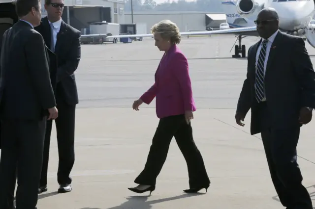 Hillary Clinton walks to a waiting car after arriving at the airport in Greenville, North Carolina