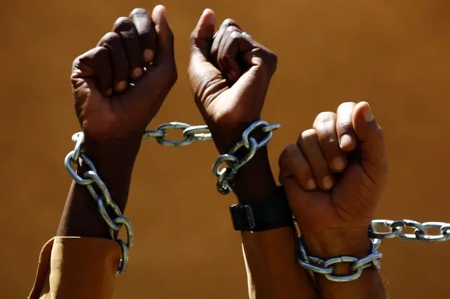 Sudanese journalists pose with chains as they gather outside the Tayar newspaper to announce their intention to begin a hunger strike on March 1, 2016, in protest of the decision to withhold the publication of the newspaper