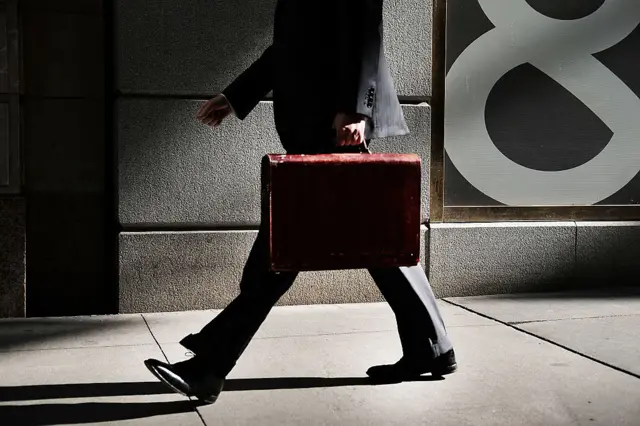 A business man walks outside of the New York Stock Exchange in New York City.