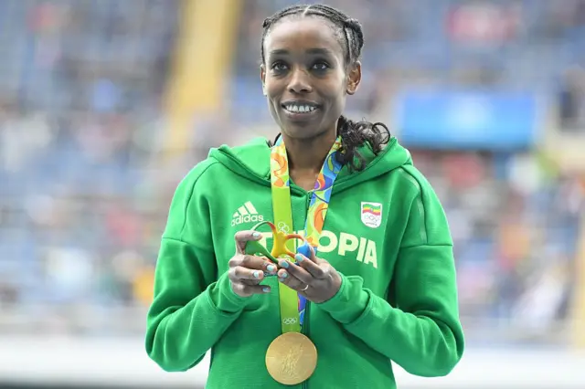 Gold medallist Ethiopia's Almaz Ayana smileson the podium during the medal ceremony for Women's 10,000m