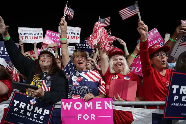 Supporters of Republican presidential nominee Donald Trump cheer as he arrives for a campaign rally in Selma, North Carolina.