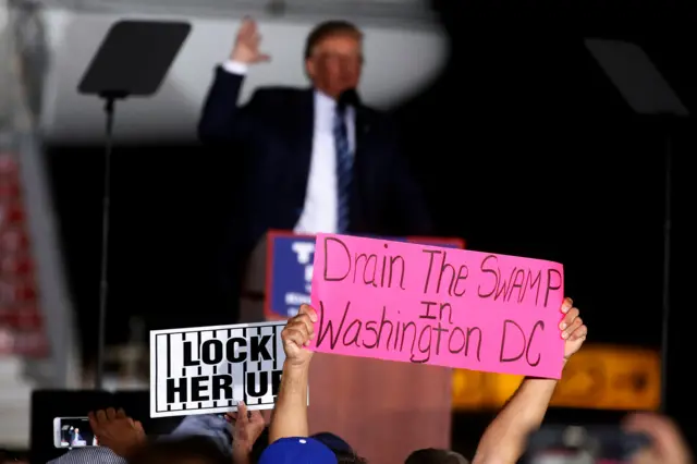 A Trump supporter holds a 'drain the swamp' sign