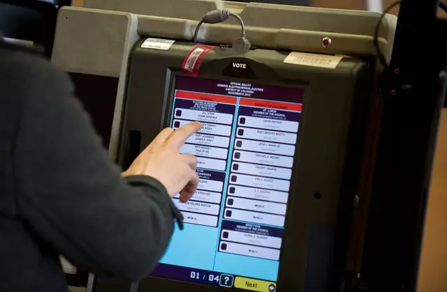 A man casts his electronic ballot at a polling station in Washington,DC in 2012.