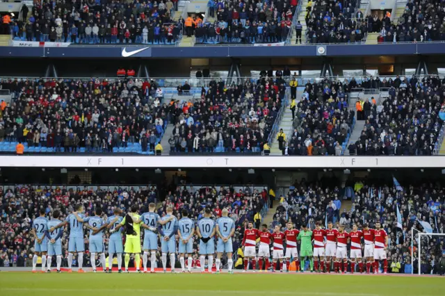 Players line up during a minutes silence