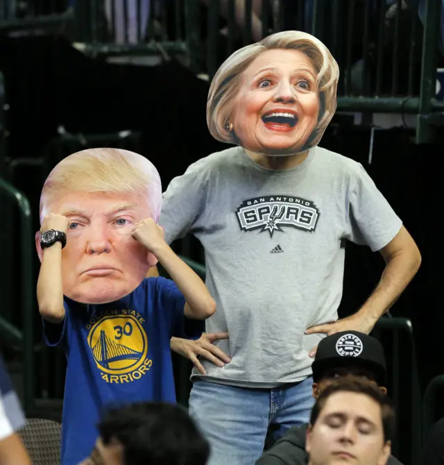 Basketball fans wear candidate masks