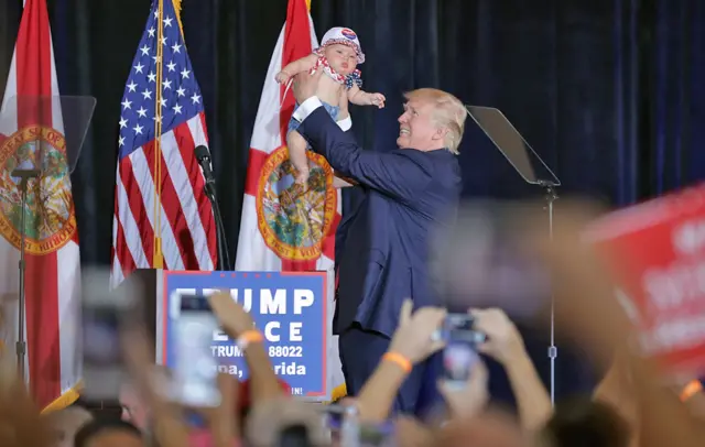 Donald Trump lifts a baby during a campaign rally in Tampa, Florida - 5 November 2016