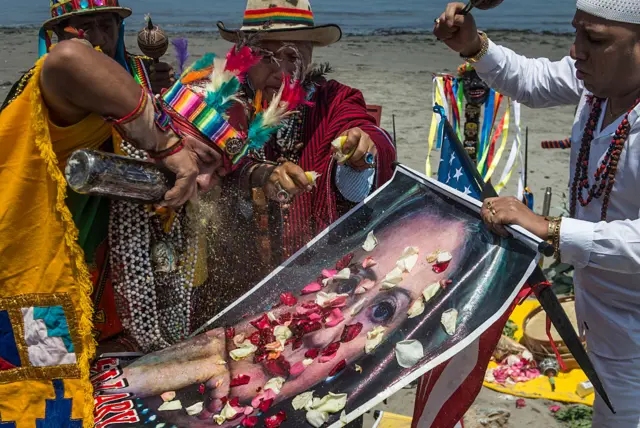 Shamans perform a ritual of predictions for the upcoming US election with posters of presidential candidates Donald Trump and Hilary Clinton at the Agua Dulce beach in Lima, Peru.