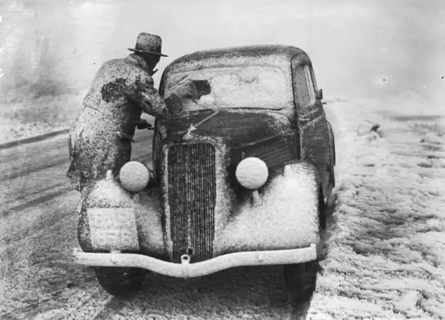 Scraping snow from a windscreen