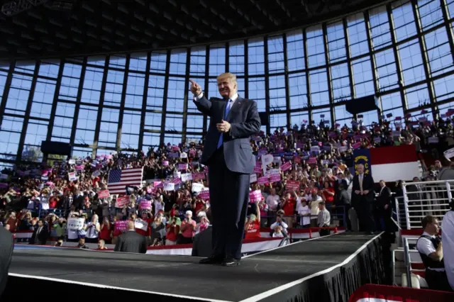 Republican presidential candidate Donald Trump points to the crowd as he arrives to a campaign rally.